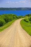 A gravel road leads towards Last Mountain Lake, a scenic area in the Qu'Appelle Valley of Saskatchewan, Canada.