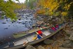 A view of two canoes hauled out on the bank of the scenic Oxtongue River during Fall in the Oxtongue River-Ragged Falls Provincial Park of Ontario, Canada.