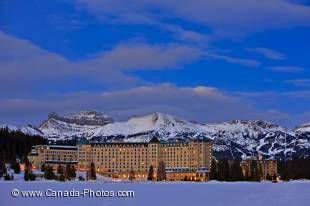 A very peaceful place in winter is the Fairmont Chateau Lake Louise as seen here at dusk with beautiful Rocky Mountains in the background, Banff National Park.