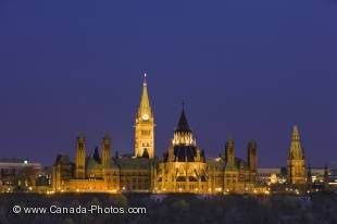 A symbol of Canadian politics, the historic buildings of Parliament Hill in the vibrant city of Ottawa stand out at dusk on the high up on the shores of the Ottawa River in the Province of Ontario, Canada.