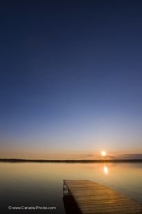 A scenic sunset over Lake Audy in Riding Mountain National Park in Manitoba, Canada from the shores of this peaceful, yet rustic, holiday location.